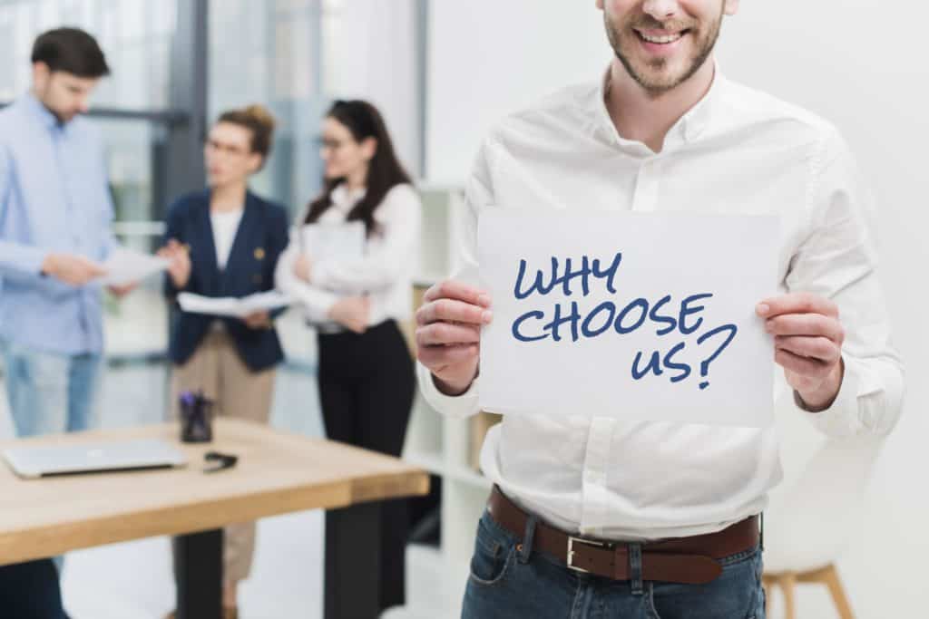business man holding paper with why choose us question
